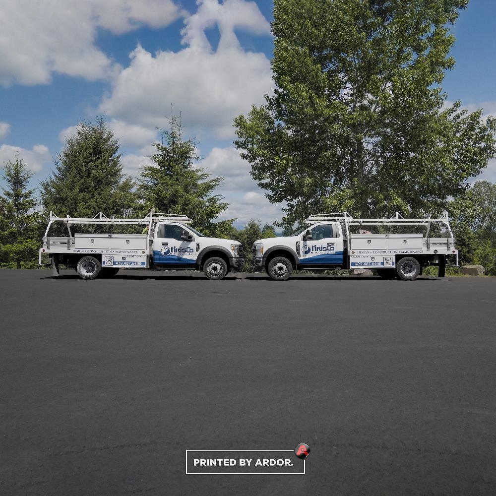 KrisCo Pools & Spas truck wraps parked side by side, featuring design, construction, and maintenance services for pools and spas.