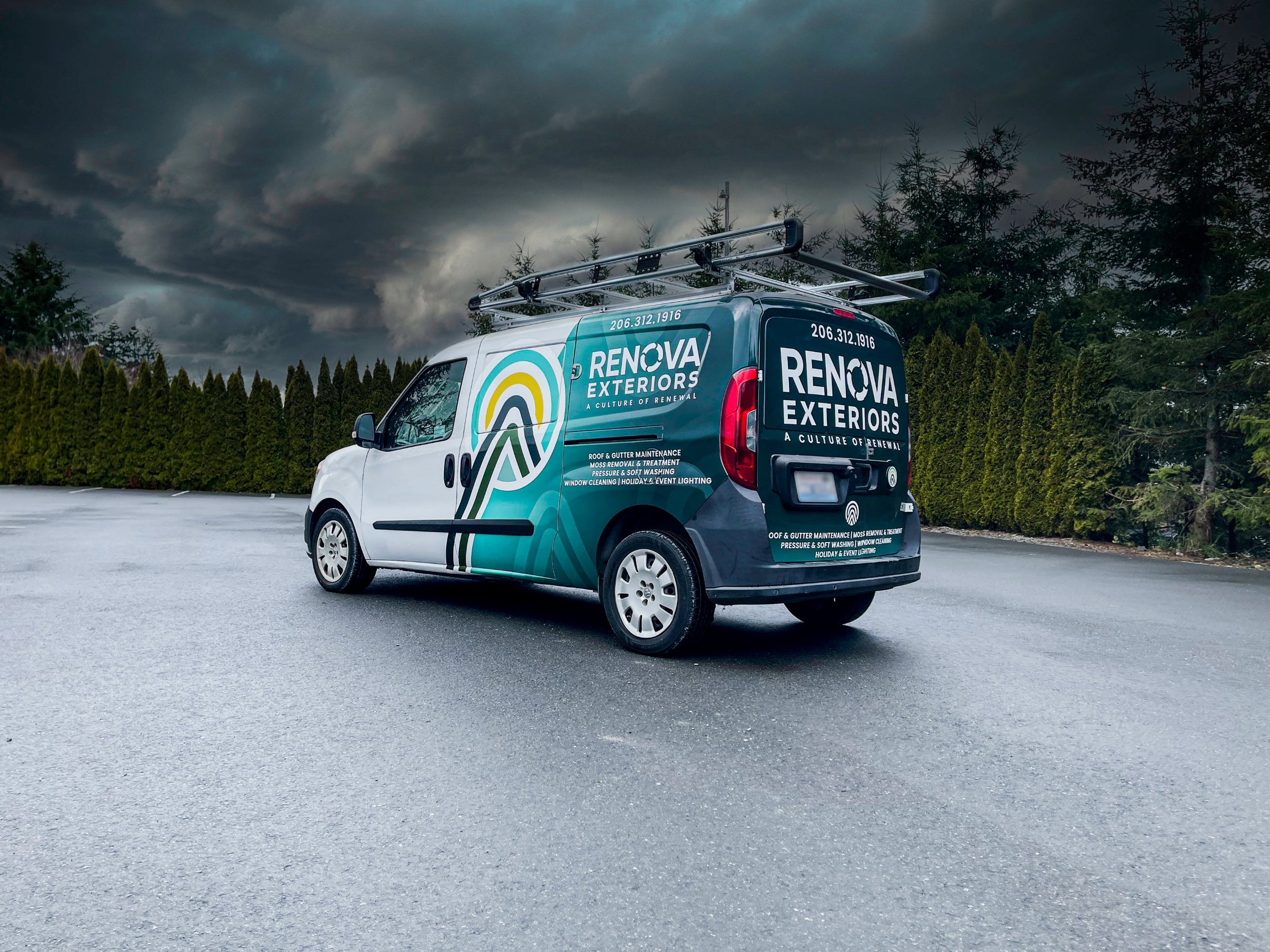 A Renova Exteriors van wrapped in teal and white, promoting exterior home maintenance services, parked outdoors under stormy skies.