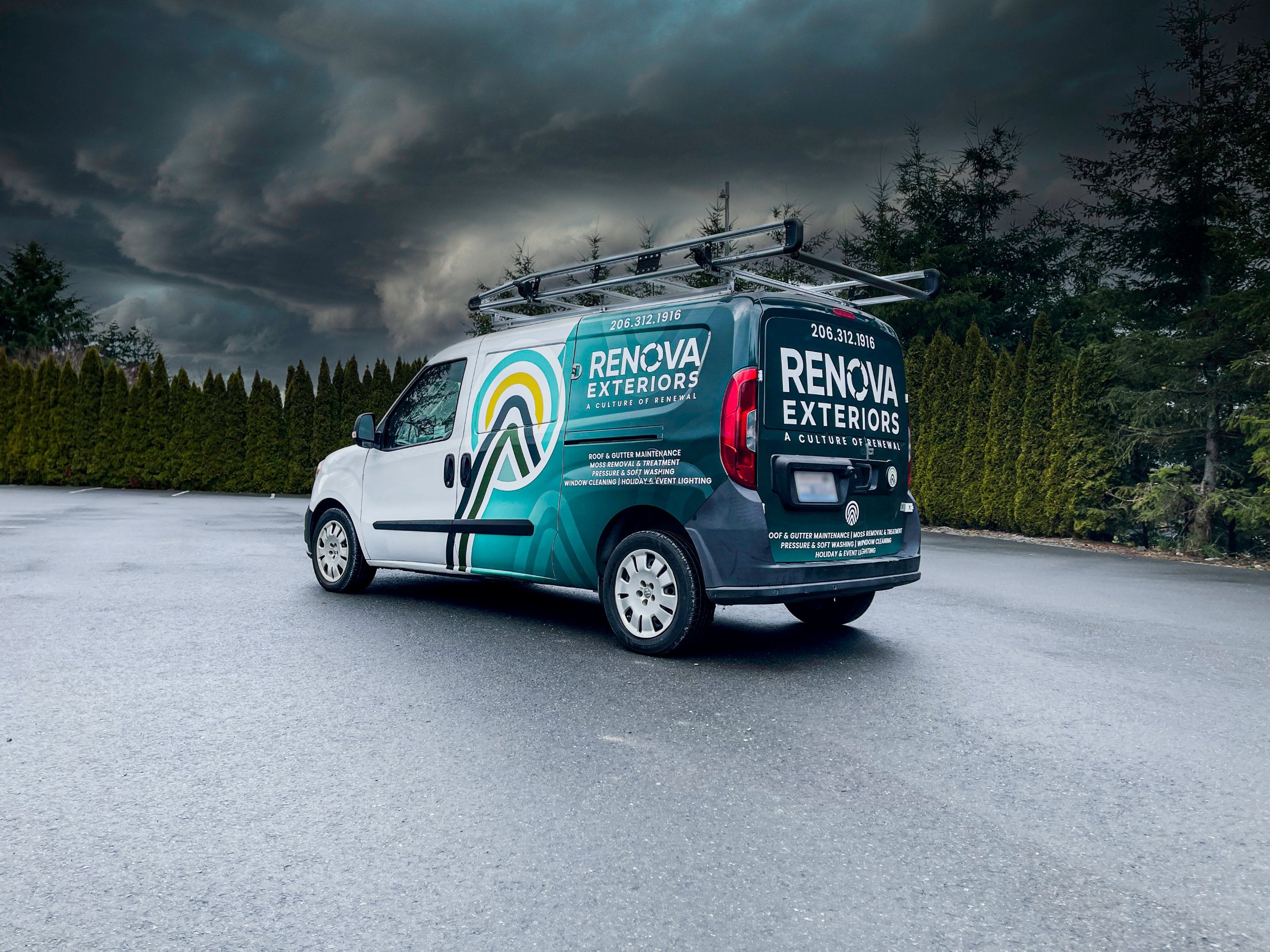 A Renova Exteriors van wrapped in teal and white, promoting exterior home maintenance services, parked outdoors under stormy skies.