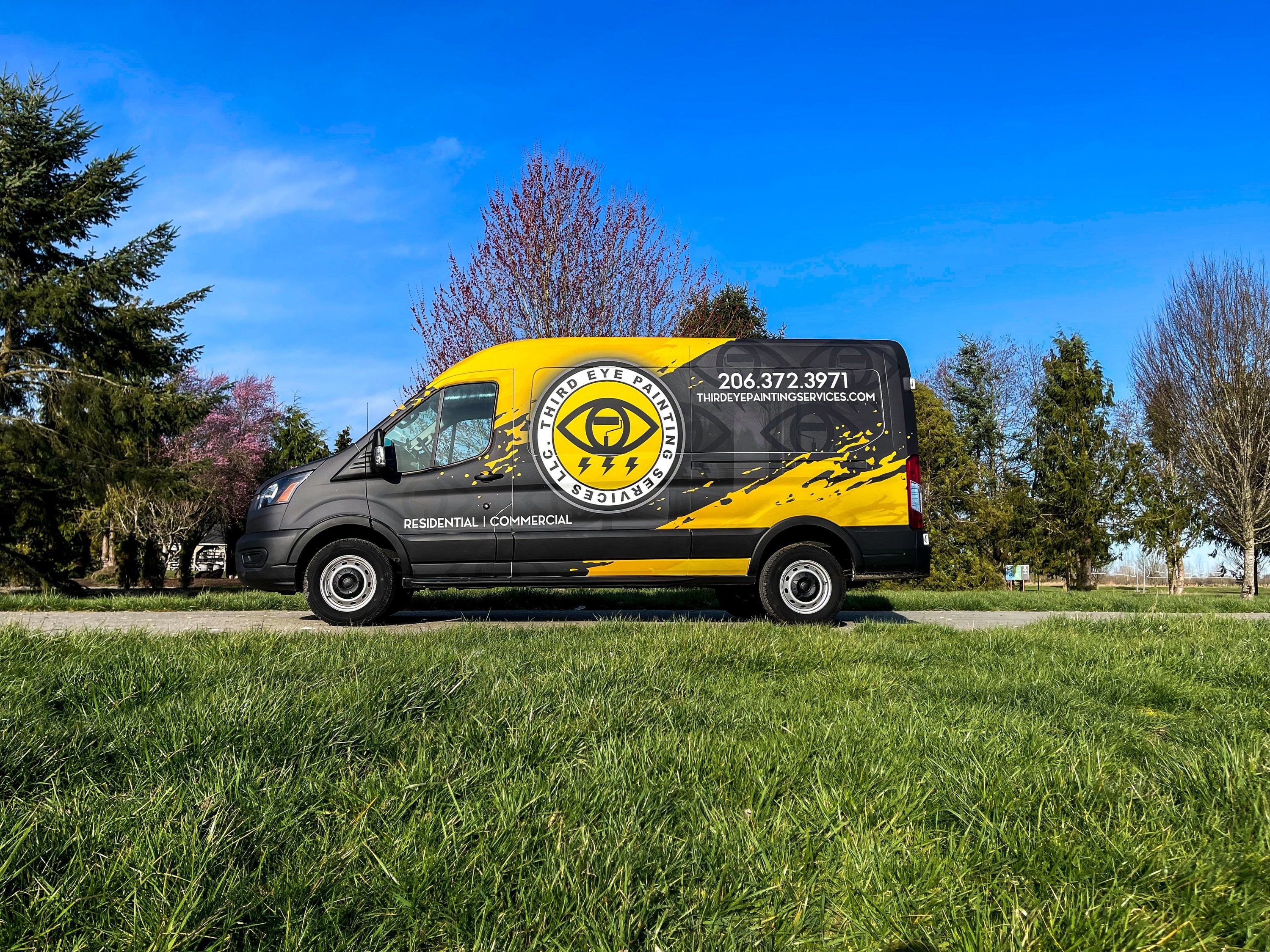 Third Eye Painting Services van with a bold yellow and black custom wrap, featuring company branding and contact details, parked on a grassy field.
