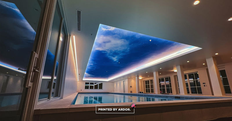 Sky-print ceiling wrap over an indoor pool by Ardor Printing