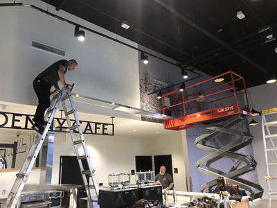Ardor Printing installer applying a large wall wrap from a lift by Ardor Printing