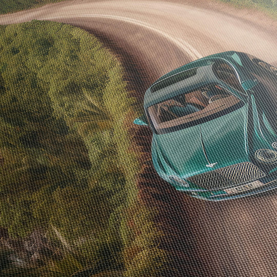 Close-up of high quality canvas print texture featuring green Bentley Continental GT on dirt road in tropical storm.