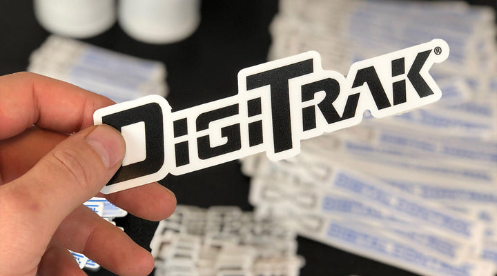 A hand holding a stylish black and white sticker, showcasing the creative possibilities of modern sticker printing.