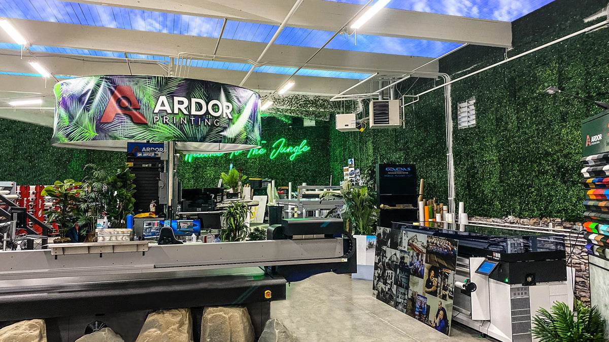Inside Ardor Printing's jungle-themed print room in Snohomish, WA, with a flatbed printer, roll printer and living plant wall
