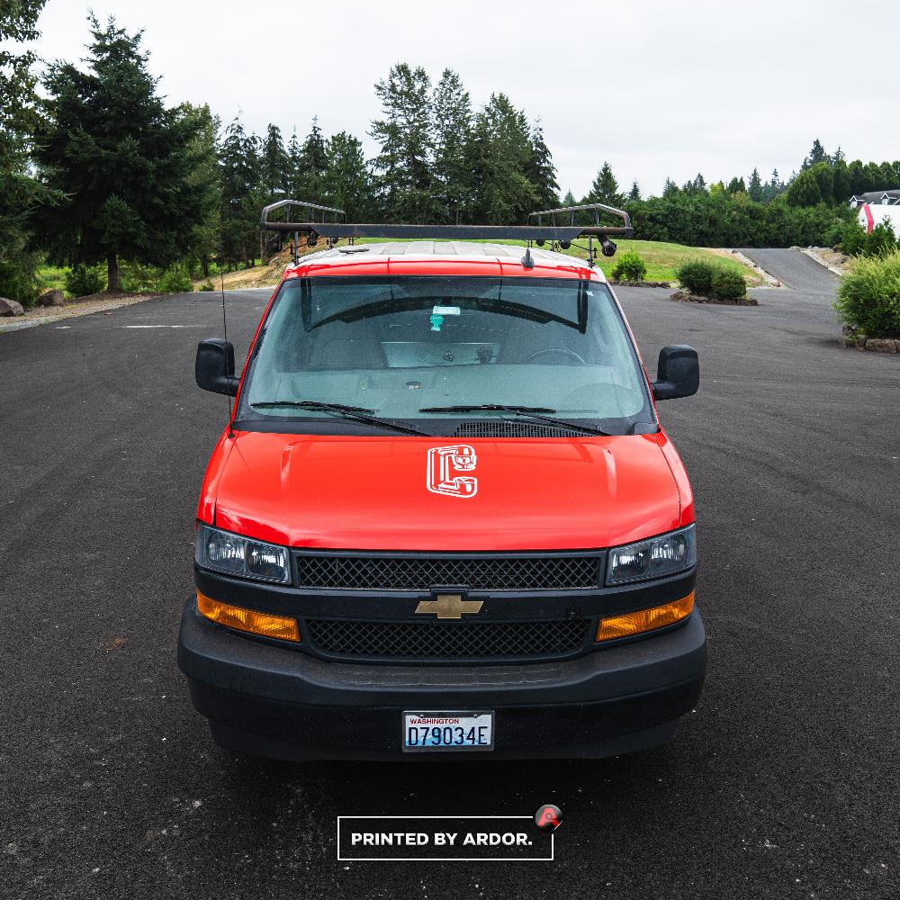 Chevrolet work van with a full vinyl wrap featuring Columbia Fire logo on the hood, captured in a clean, professional front-facing shot.