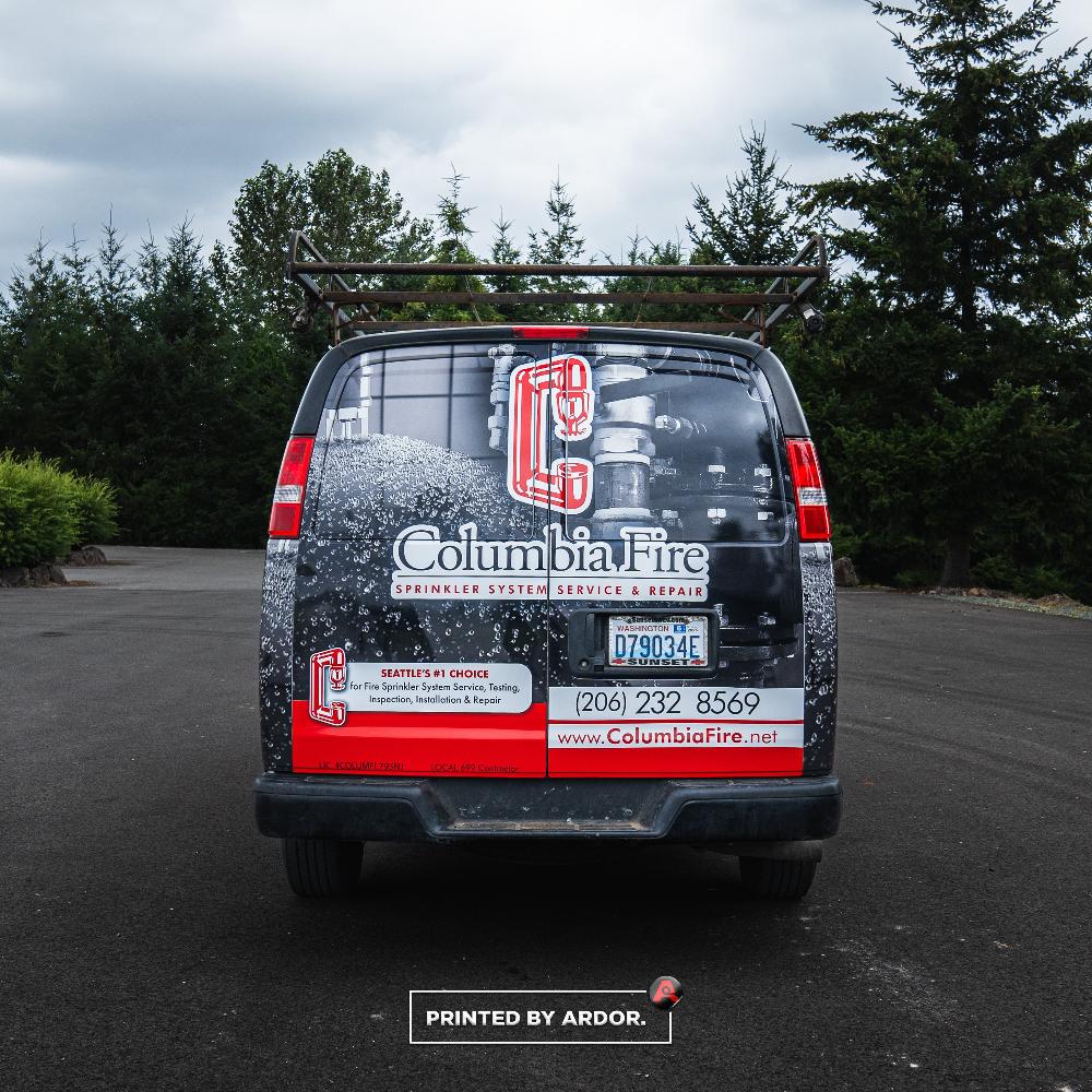 Columbia Fire van's back wrap features sprinkler system imagery, website, and phone number, highlighting their fire protection services.