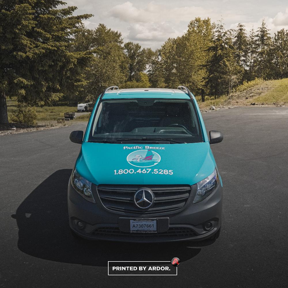 Front view of Pacific Breeze van wrap displaying the company logo and 1-800 contact number in bold on a teal background.