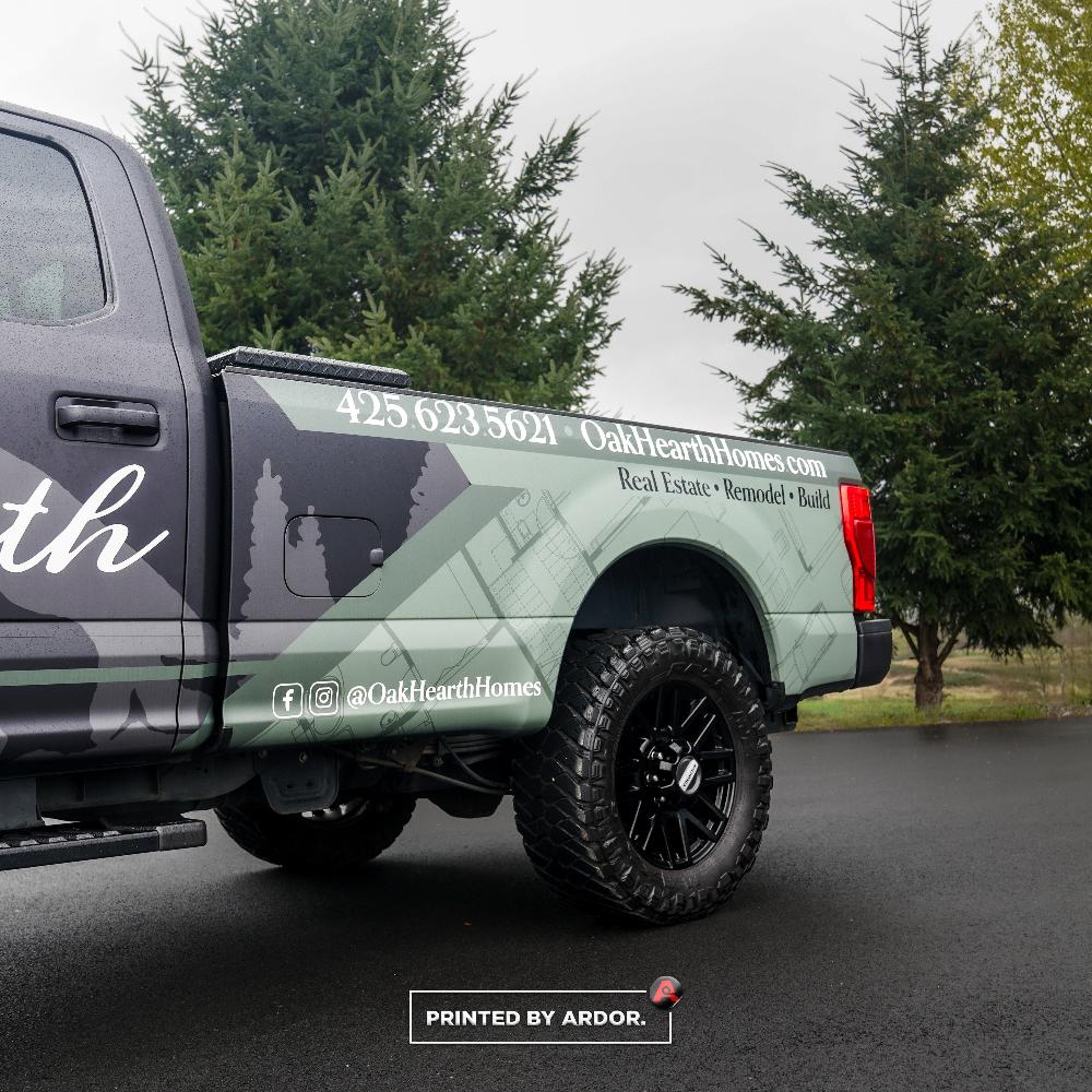 Oak Hearth Homes truck wrap showcases sleek design with forest silhouettes and contact details, building trust on the road!