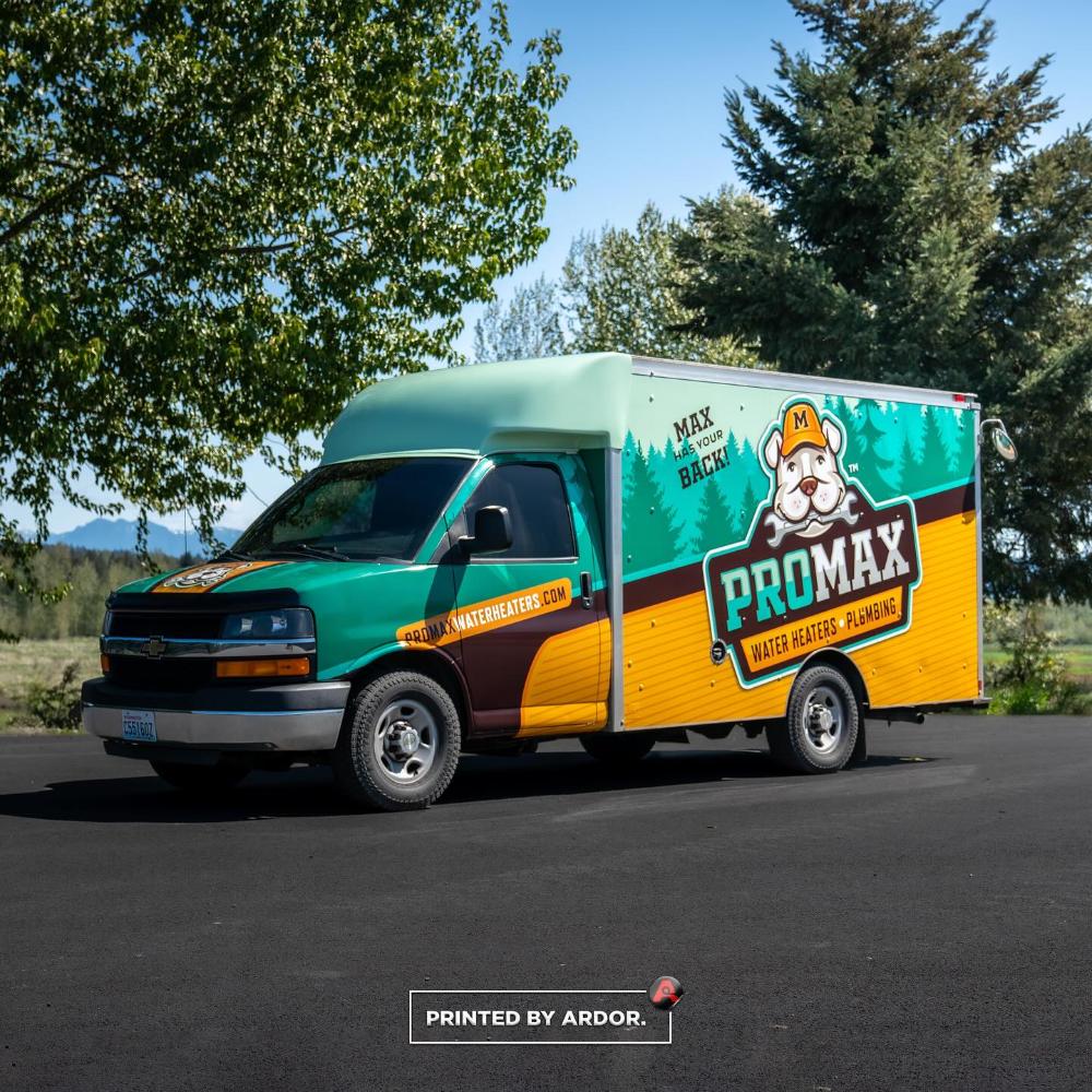 ProMax Water Heaters truck with a vibrant wrap featuring a mascot and forest design, promoting water heater and plumbing services, parked near trees.