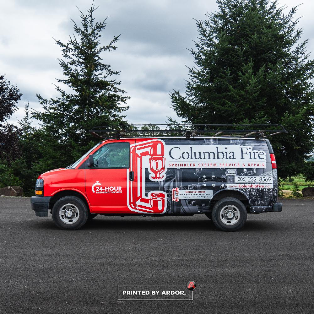 Columbia Fire van wrap with bold red and black design, featuring sprinkler system graphic and 24-hour emergency services.