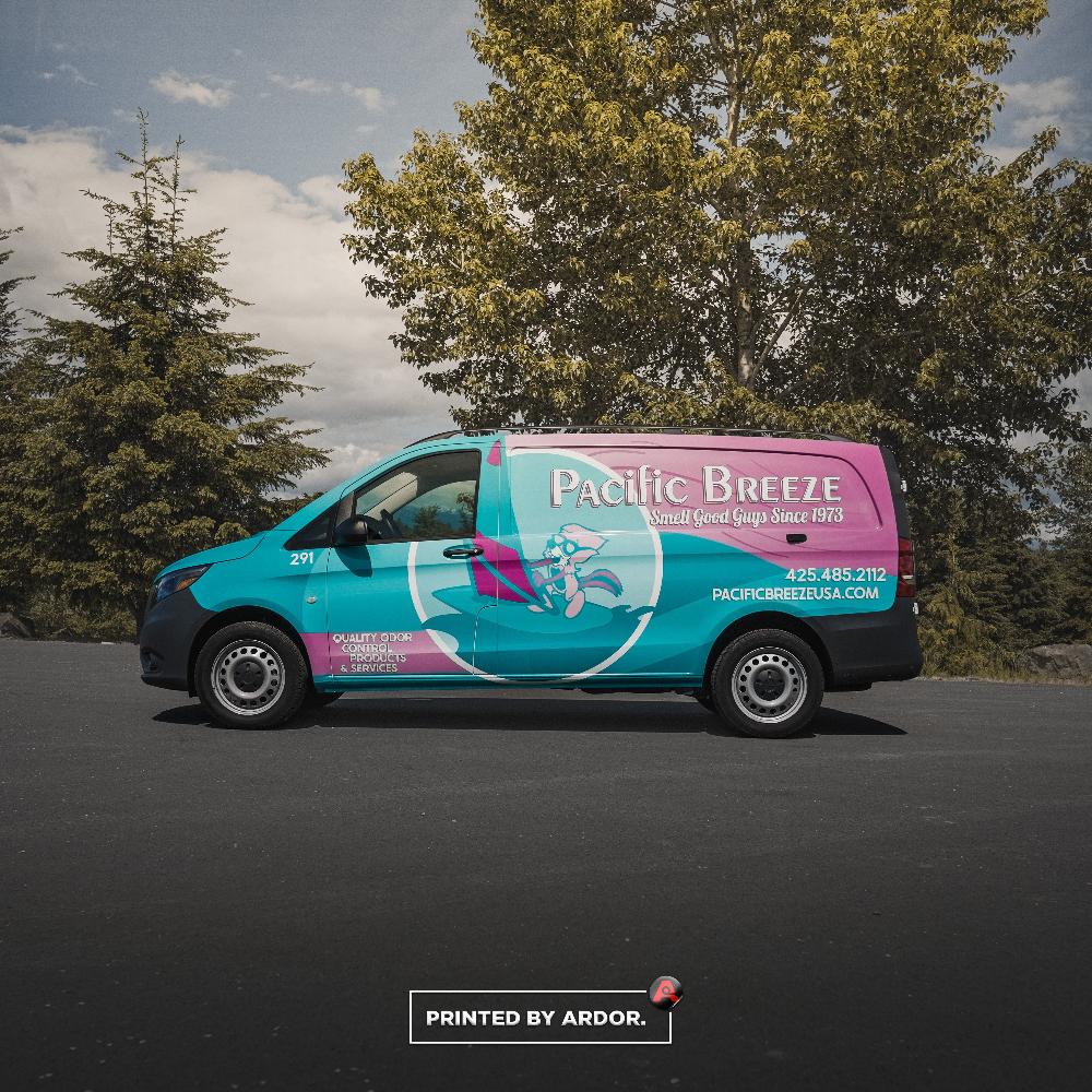 Bright Pacific Breeze van with teal and pink wrap, promoting odor control services with bold text and graphics.