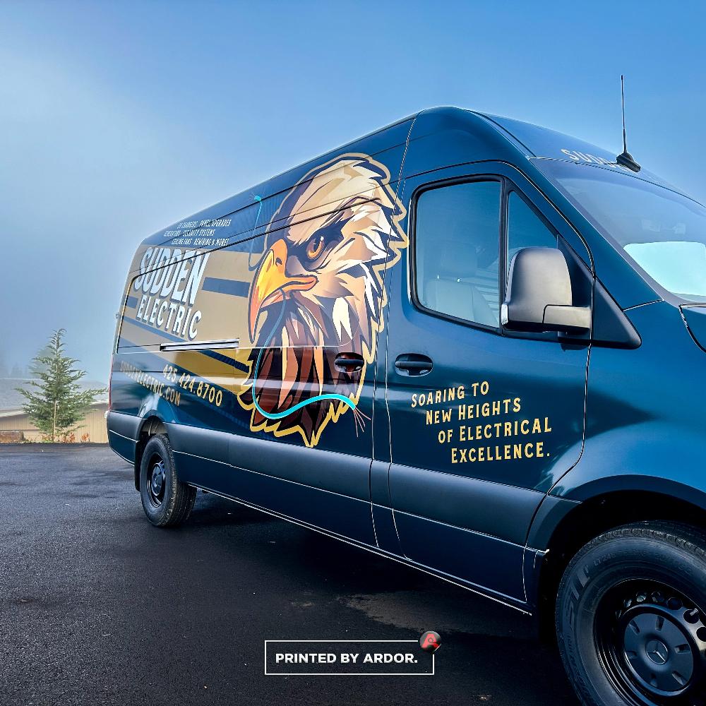 Close-up of Sudden Electric van wrap featuring a large eagle logo and the slogan 'Soaring to new heights of electrical excellence.