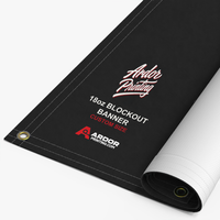 Custom 18oz blockout banner printed with Ardor Printing branding, partly rolled to show the hemmed edge and brass grommets