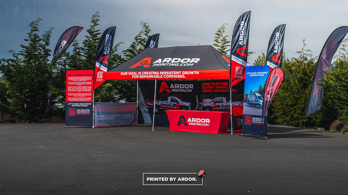 Red Ardor Printing event tent with feather flags, a retractable banner stand and a printed table cover