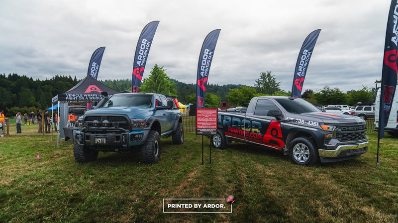 Ardor Printing event booth with custom feather flags, a printed pop-up tent and wrapped trucks