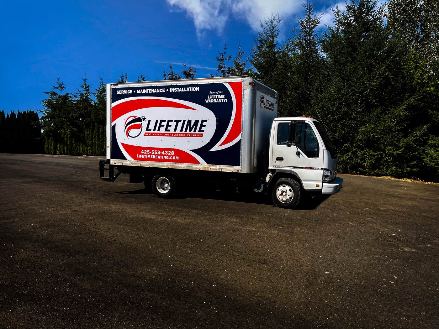 White box truck wrapped in navy and orange Lifetime heating, cooling, electric and plumbing graphics with phone and website