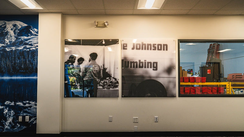 Black and white company history photos printed on acrylic for a plumbing company office by Ardor Printing