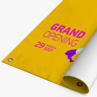 Printed 13 oz vinyl banner with hemmed edges and grommets, partly rolled
