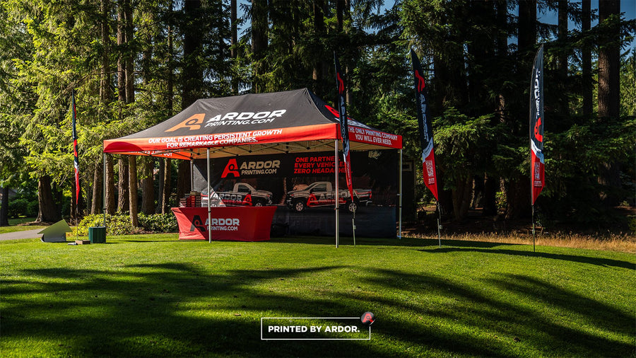 Custom printed 10x20 pop-up tent with logo at an outdoor golf event