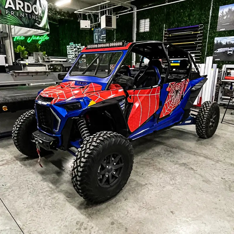 Spider-Man themed red and blue Polaris RZR wrap parked in Ardor Printing's print room