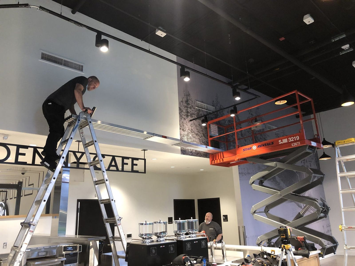 Ardor Printing installer applying a wall wrap from a scissor lift
