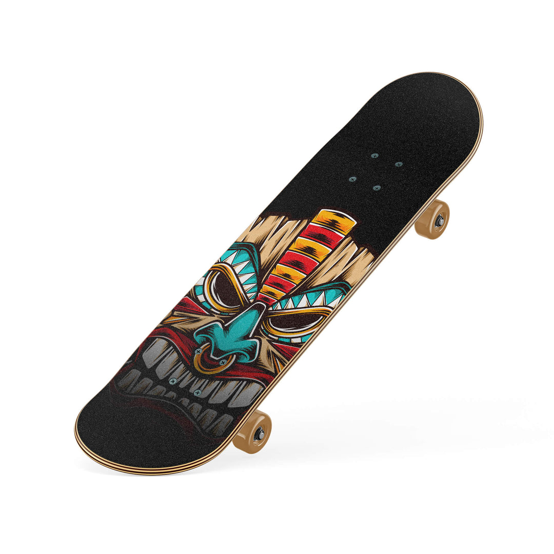 Slanted view of skateboard showcasing colorful wood tiki mask design on grip tape, with vibrant blues, reds, and brown accents.